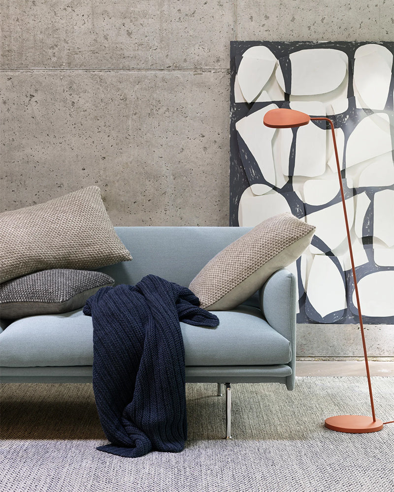 Ample- Blåt throw tæppe fra Muuto, taktil underspillet struktur i blåt garn, på gulv ved sofa